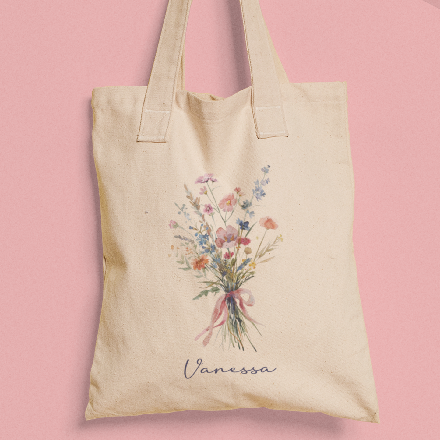 Totebag van katoen met een watercolor boeket bloemen en de naam 'Vanessa' op roze achtergrond