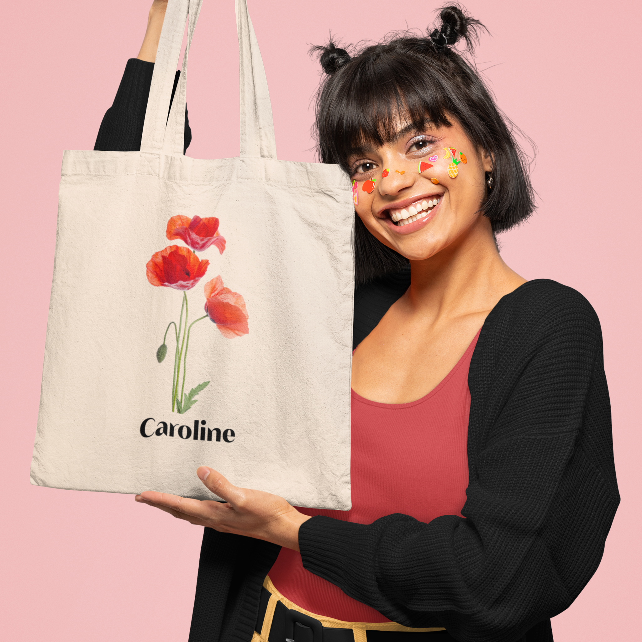 meisje die lacht met een Gepersonaliseerde totebag met klaprozen en naam in haar hand