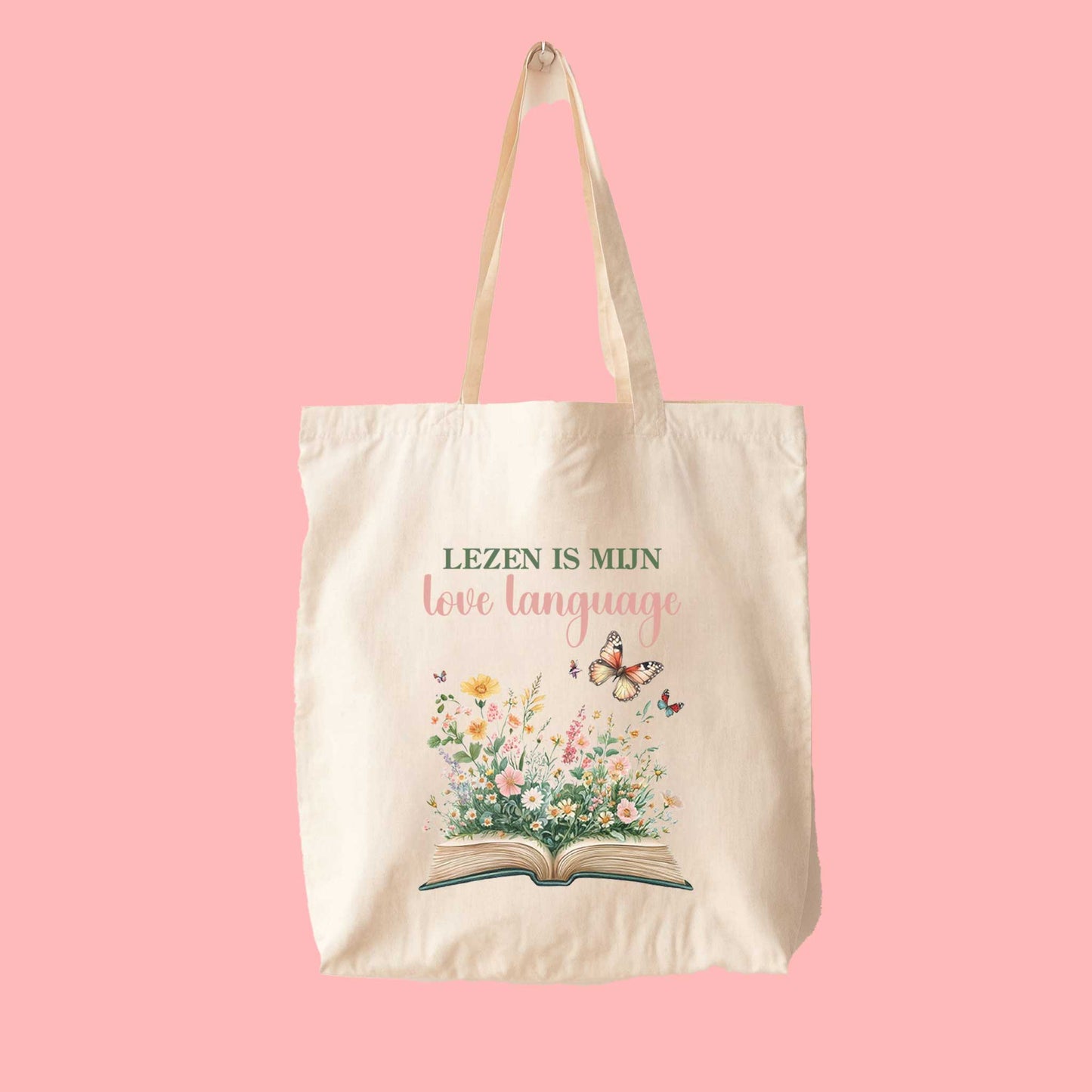 Totebag met quote Lezen is mijn love language en illustratie van boek en bloemen op roze achtergrond
