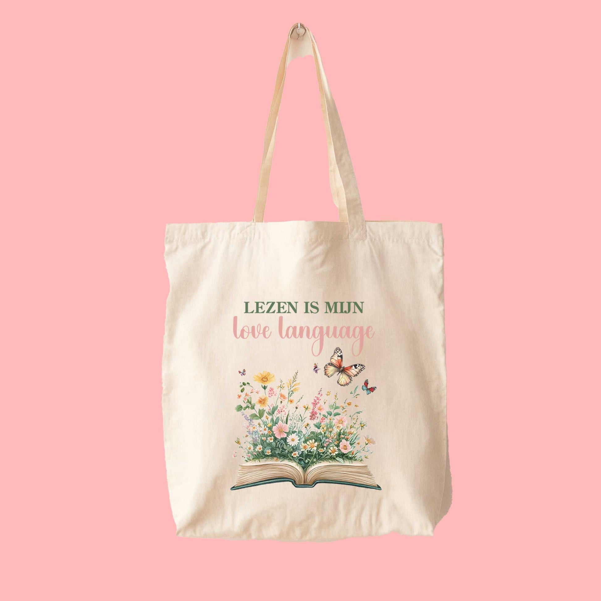 Totebag met quote Lezen is mijn love language en illustratie van boek en bloemen op roze achtergrond