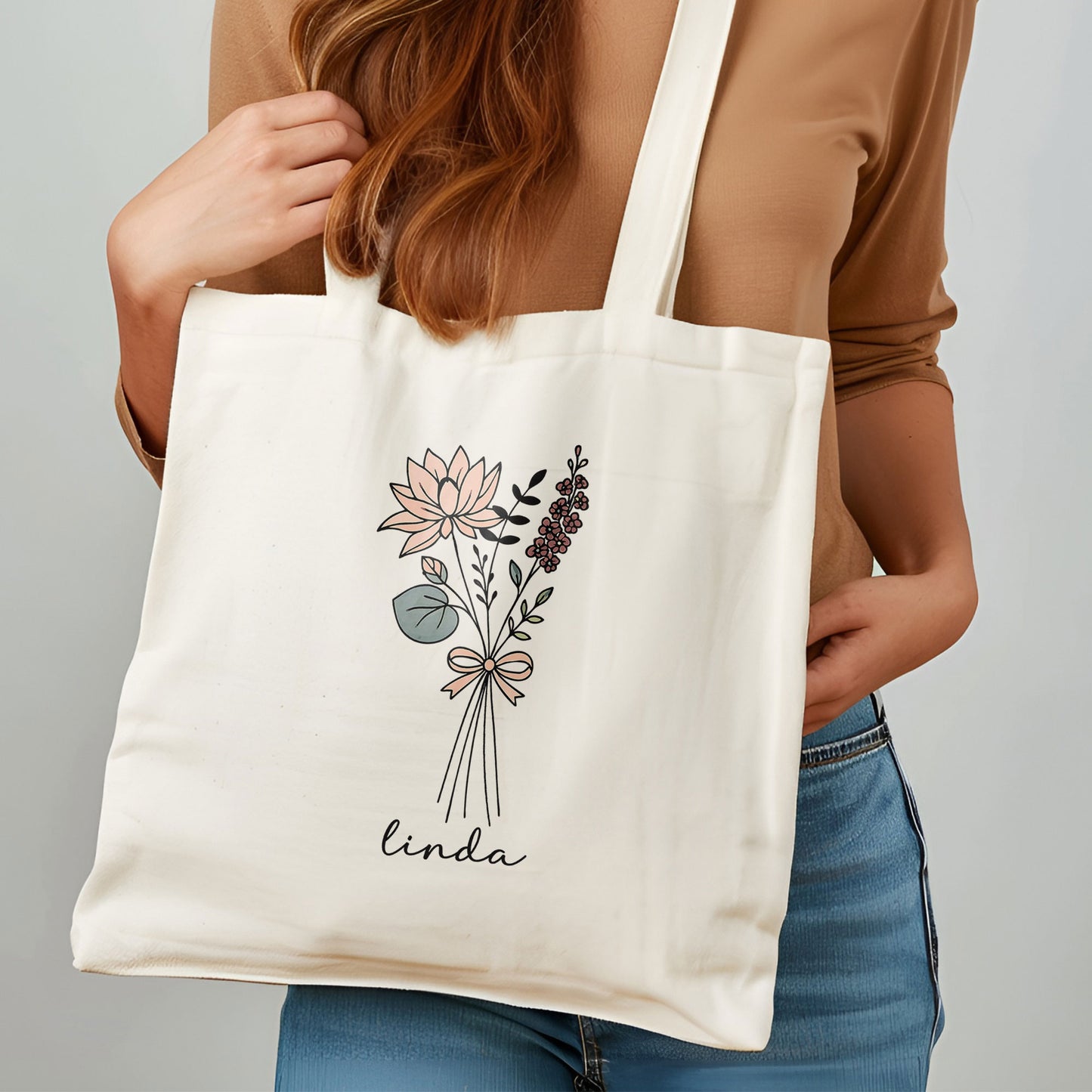 Vrouw draagt gepersonaliseerde totebag met naam Linda en bloemen lijntekening