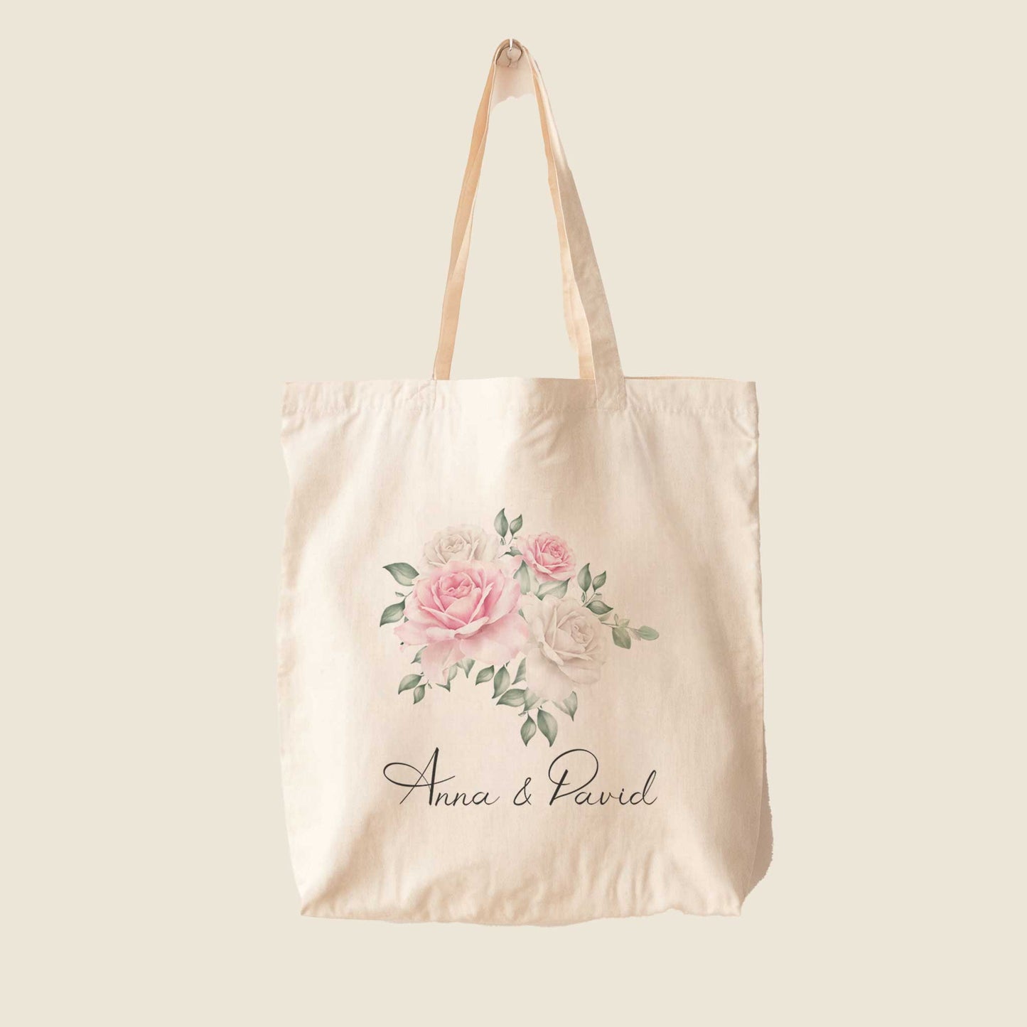 Tote bag met roze en witte rozenillustratie en namen Anna & David, op effen beige achtergrond