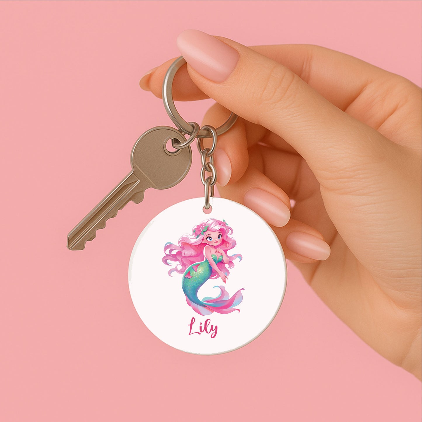 Hand met roze nagels houdt een sleutelbos vast met een gepersonaliseerde sleutelhanger waarop een zeemeermin met bloemenhaar en de naam Lily staat.