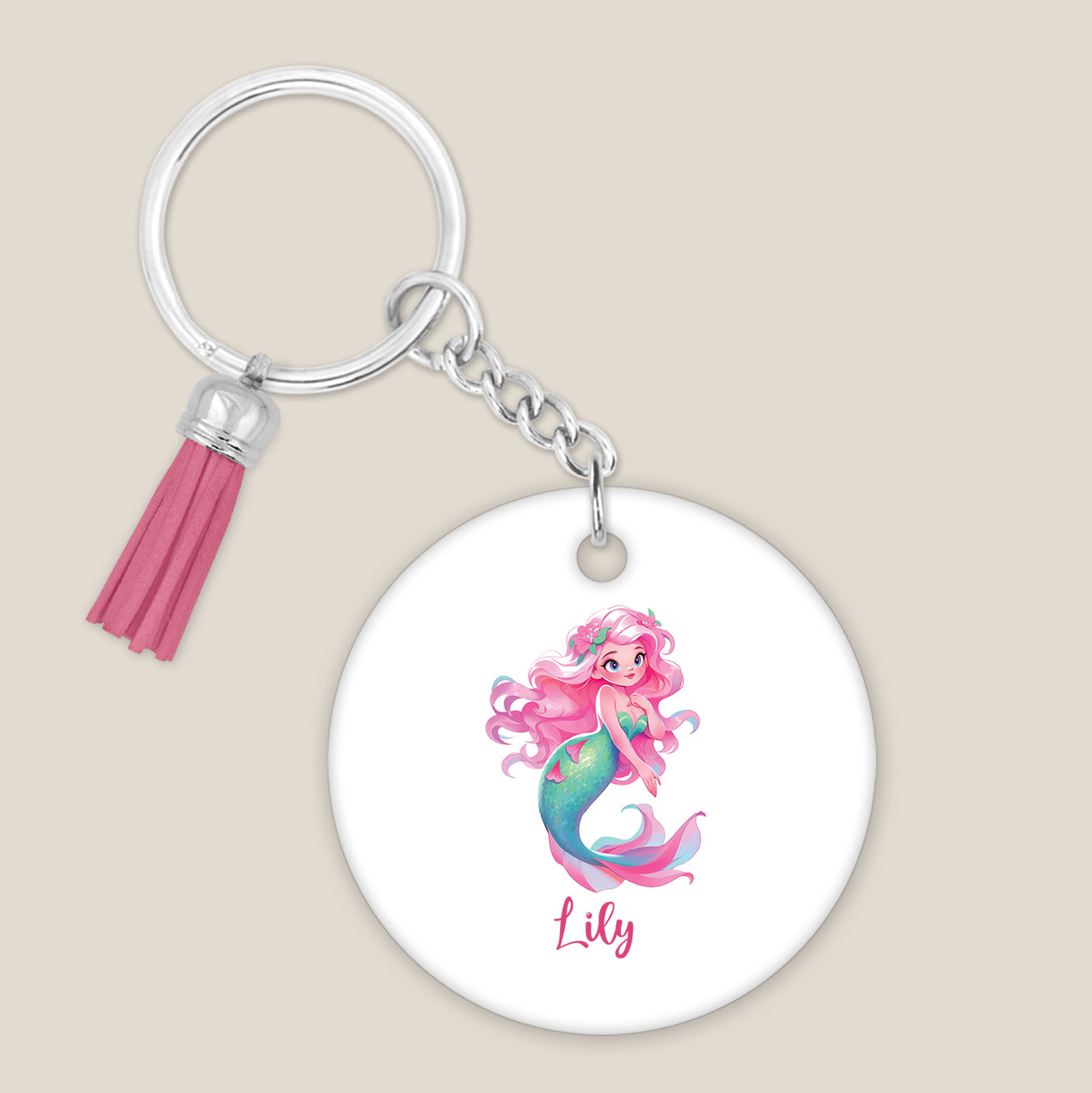 Ronde sleutelhanger met roze kwastje, zeemeermin met bloemenhaar en naam Lily op een lichte beige achtergrond.