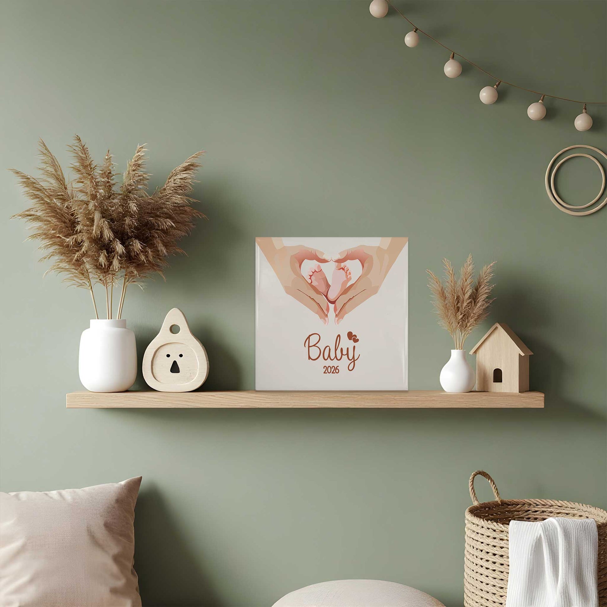 Keramisch babytegeltje met babyvoetjes illustratie op houten plank in groene boho babykamer met droogbloemen en neutrale decoratie